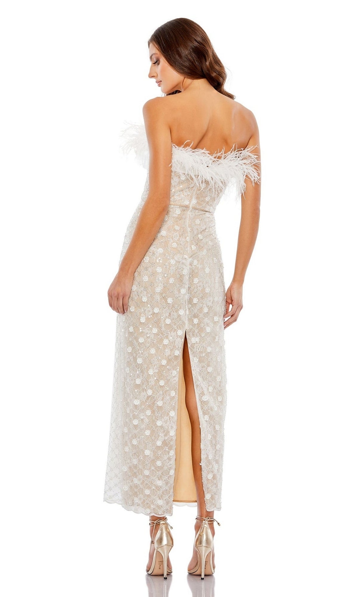 A woman in the Mac Duggal 68140 Feather Strapless Formal Dress—an elegant white lace design with feather trim and back slit—stands in high-heeled sandals against a white background.